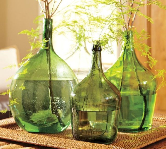 glasflaskor-gröna-ormbunkar-naturfiberbricka