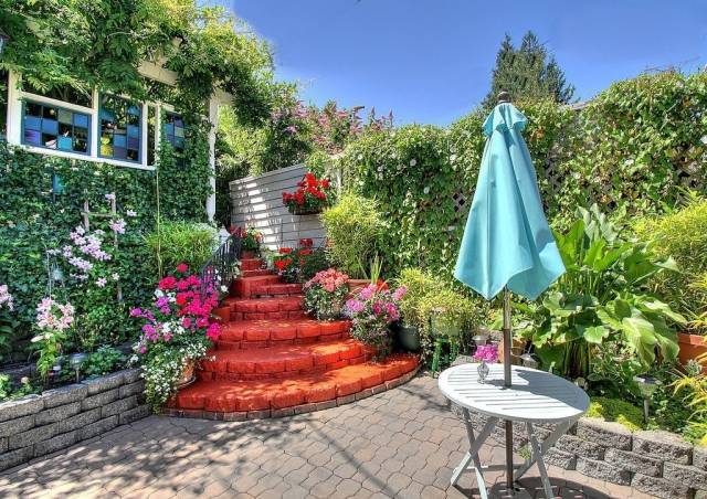 Rödfärgad-trappa-rosa-blommar-trädgård-design-med-pittoresk-tillväxt