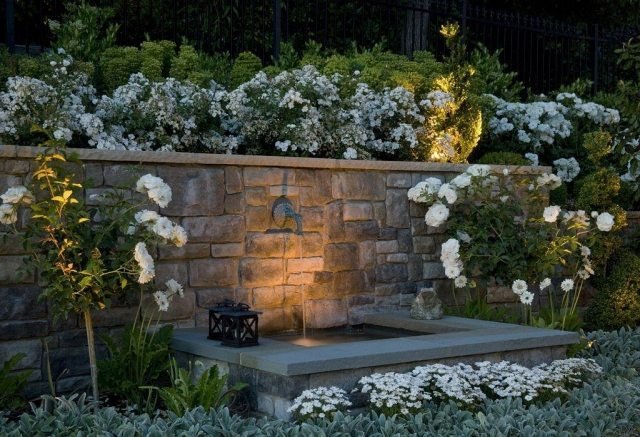 Trädgård-kvarhållande-vägg-sten-vägg-fontän-belysning-kuperat-landskap