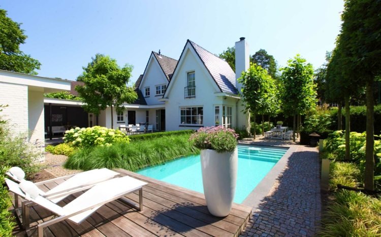 idéer-trädgårdsdesign-modern-stenläggning sten-trä-terrass-schäslong-pool kant-prydnadsgräs