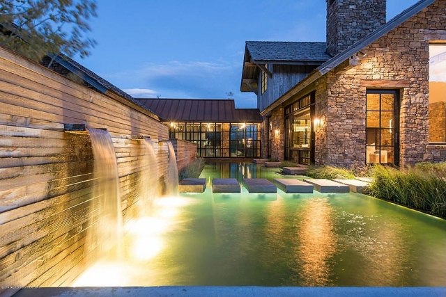 Hus-med-sten-fram-sekretess-skärm-vägg-vattenfall-pool-belysning-stenar
