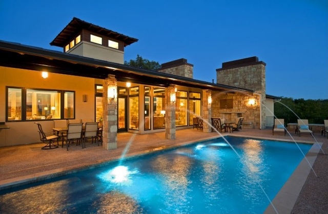 fritidshus-med-utomhus-vardagsrum-natursten-fasad-simning-pool-fontän-belyst