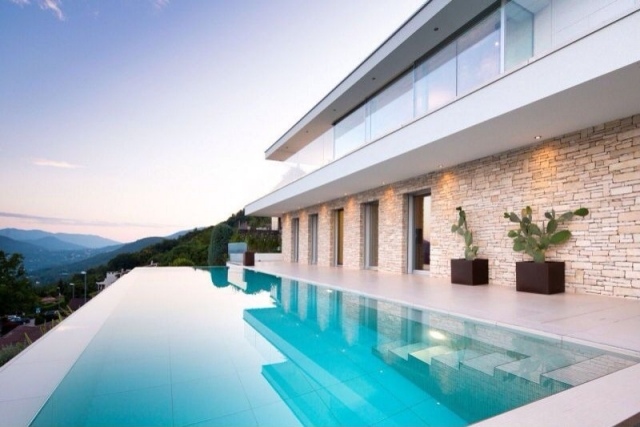 modernt hus-med-sten-fasad-blomma-badkar-infinity-pool