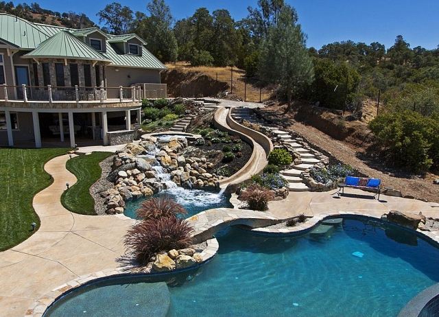 modernt-semester-hem-kuperat-läge-naturlig-atmosfär-trädgård-pool-med-bro-vatten-rutschbana-fontän