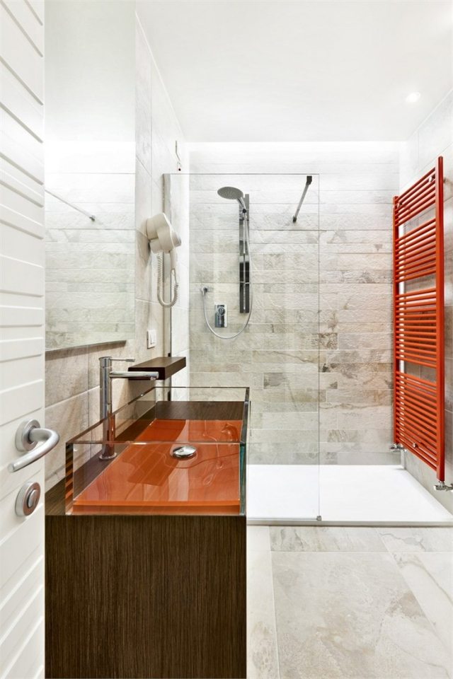 Badrumsdesign-natursten-kakel-glas-handfat-underskåp-badrumsradiator-röd