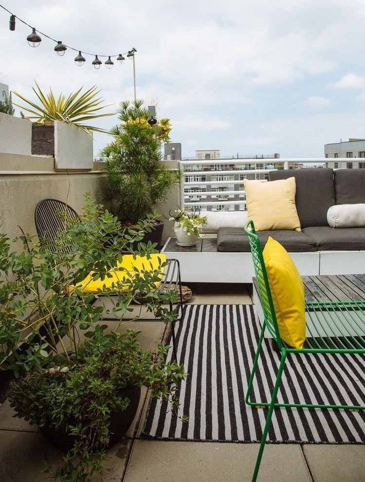 vardagsrum-fri-betong-plattor-utomhus-matta-gröna-växter-gula-accenter
