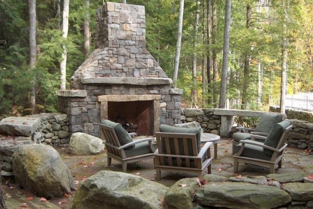 rustikt-vardagsrum-utomhus-öppen spis-med-skorsten-sten-terrass-naturlig-atmosfär