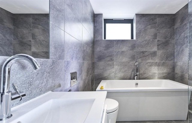 badrum-modern-grå-vägg-kakel-matt-badkar-fönster