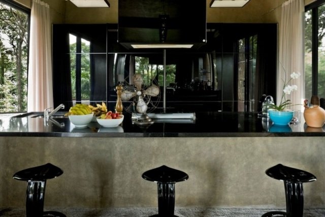 Högglansat kök, bänkskiva i svart lack, massiv betongkonstruktion, designerstolar