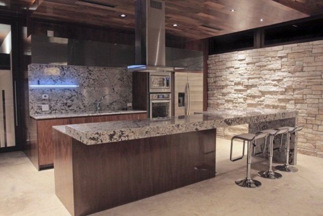 modernt kök trä köksskåp granit bänkskiva natursten vägg