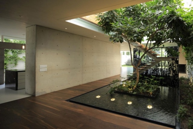 modernt hus inomhus trädgård damm exponerad betongvägg