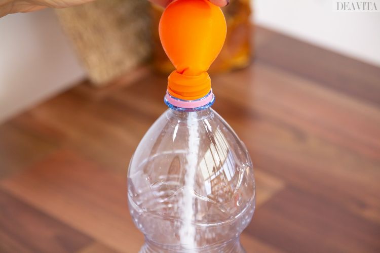 Enkla experiment för barn att hälla en ballong runt flaskhalsen av bakpulver