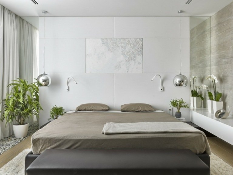 12 kvm rum inredda i minimalistisk stil med en säng utan sänggavel och speglar på väggen