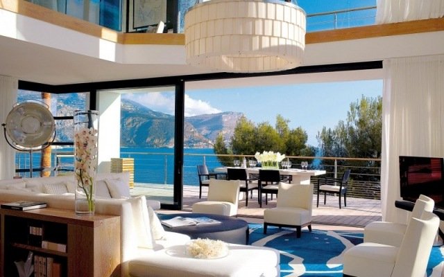 villa-vardagsrum vardagsidéer exotisk stil design-högt i tak-låg fåtölj-vit