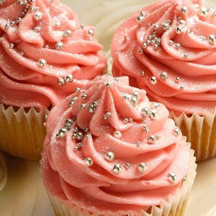 dessert till nyårsaftonsmuffins-vanilj-deg-söt-smörkräm-huva-rosa-glitter-socker-pärlor