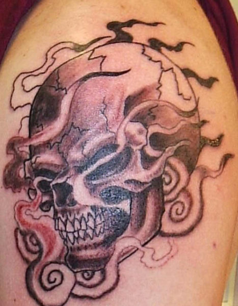 Σχέδιο τατουάζ φλεγόμενου κρανίου στο μπράτσο