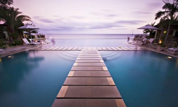 Infinity-pool-med-havsutsikt-broar-gjorda av trä-exotiska-bygga