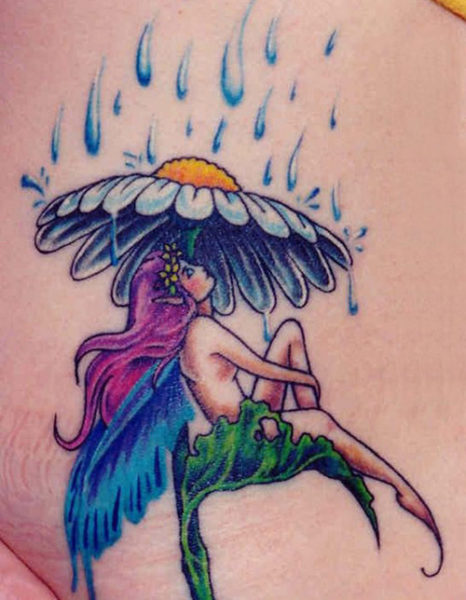 Keiju istuu sateen keiju -tatuoinnin alla