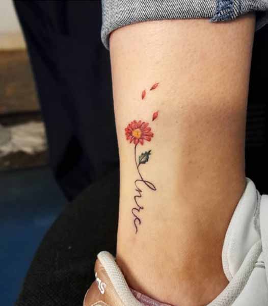Pieni gerbera päivänkakkara tatuointi jaloilla