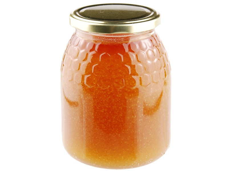 Σπιτικό μέλι σε γυάλινο βάζο σε λευκό