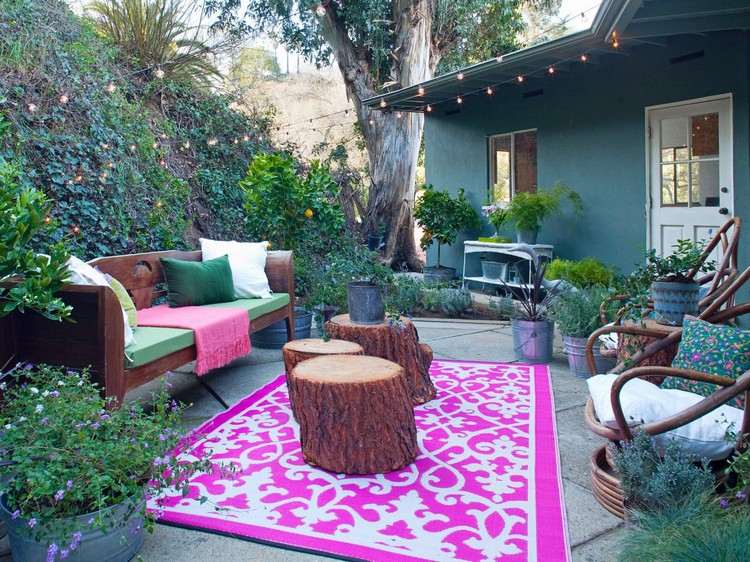 Trädgårdsterrass i bohemisk stil stenplattor-golv-rosa-utomhus-matta-träd-stamm-sidobord