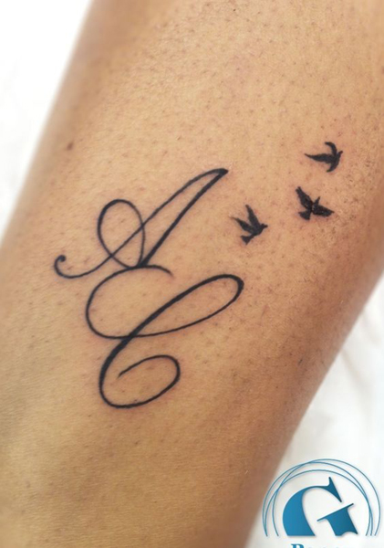 A ja C tatuointi kahden pienen linnun kanssa