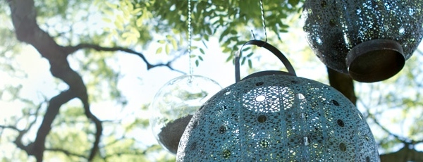 Filigran ljuslyktor som hänger på terrängträdgården