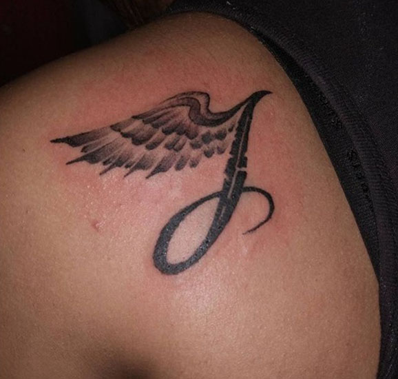 Lentävä J -kirjain -tatuointi siivillä
