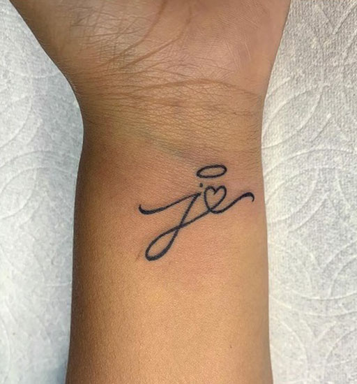 Κομψό τατουάζ στον καρπό με μια καρδιά και ένα Halo