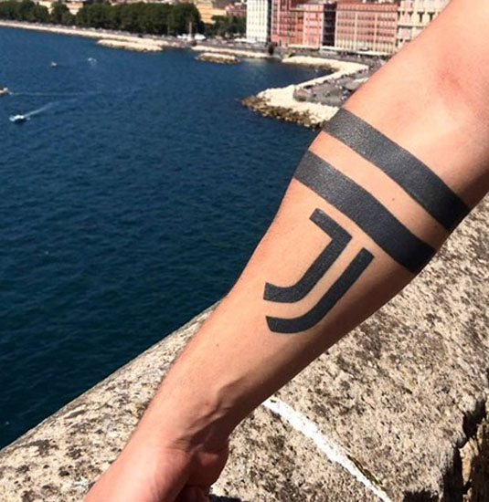 Lihavoitu J -kirjain tatuointi käsillä