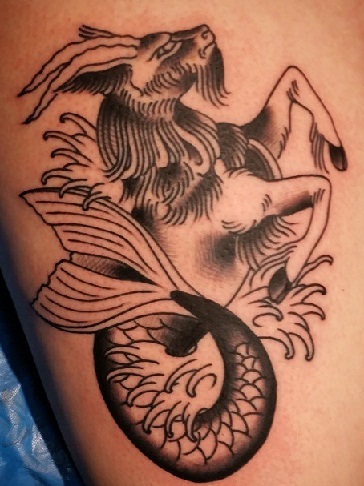Γλυκό σχέδιο του τατουάζ Αιγόκερω στο μηρό