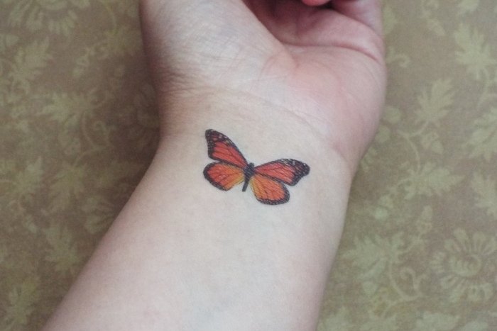 monak-fjäril-tatuering-tatuering-på-handleden-med-färg-design