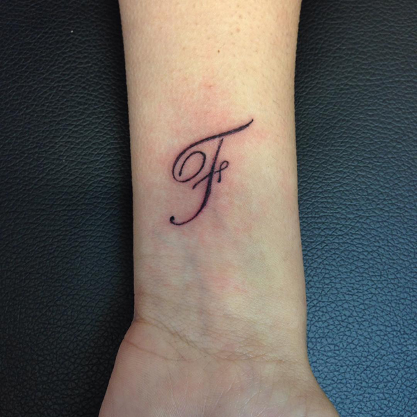 Voguish F -kirjeen tatuointi ranteessa
