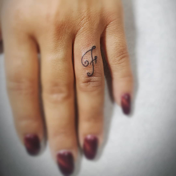 Kursiivinen F -sormen tatuointi