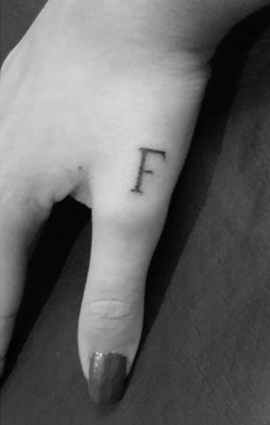 Kirjain F Tatuointi peukalolla