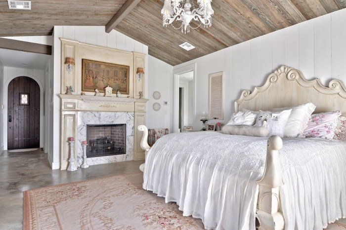 romantisk-sovrum-möbler-lantlig-ljuskrona-vit-vägg-öppen spis