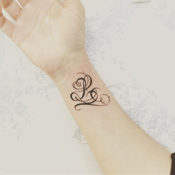 Tyylikäs L -kirjain -tatuointi ranteessa
