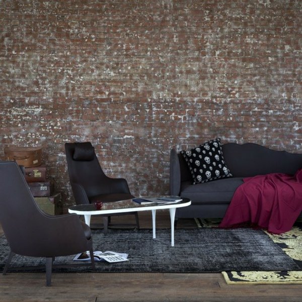 Tegelvägg grå möbler lila överkast design idé