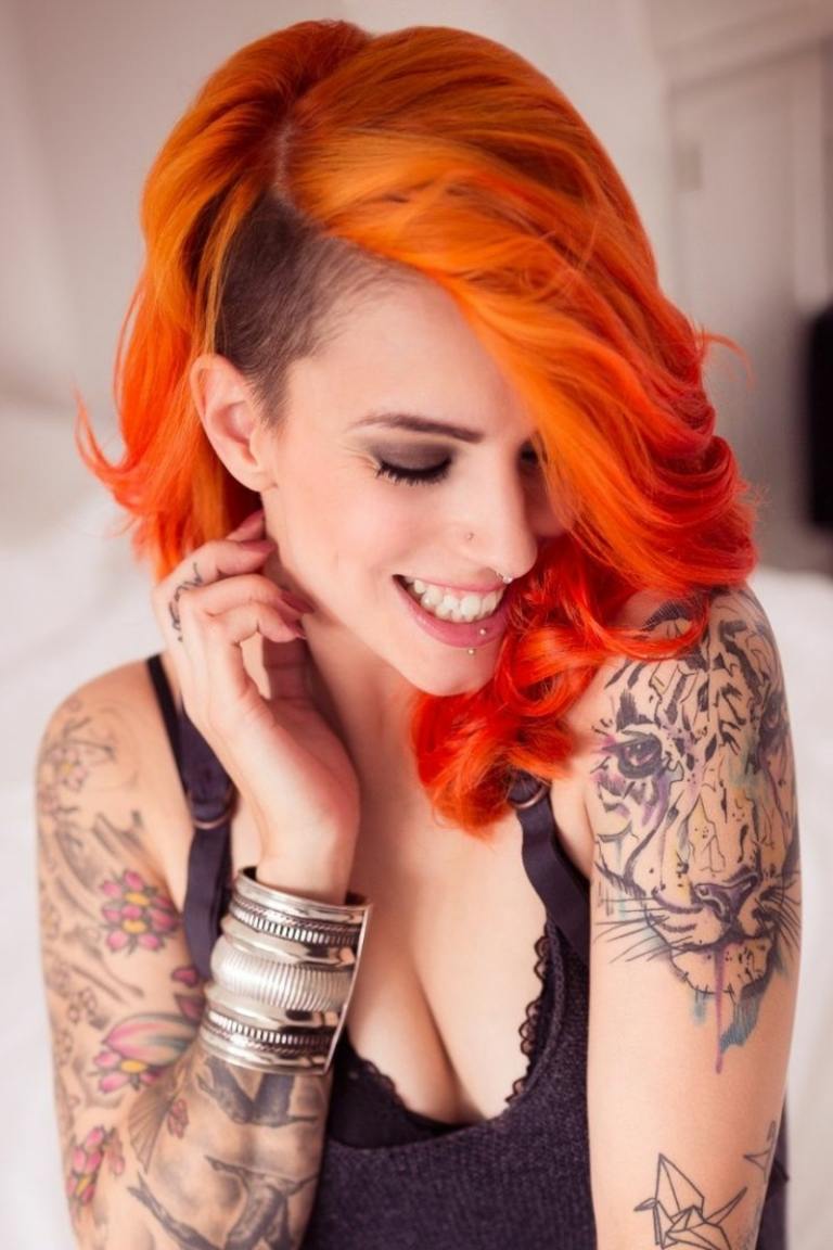 Bygg frisyr med underskuren orange hår attraktiva tatueringar