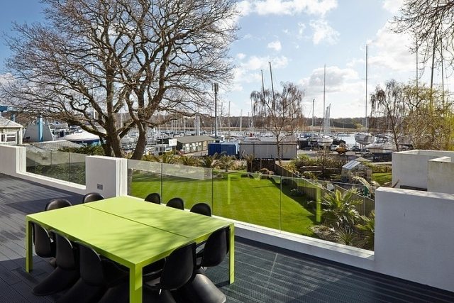 terrass-modern-designad-glas-balustrade-grönt-matbord-svart-stolar