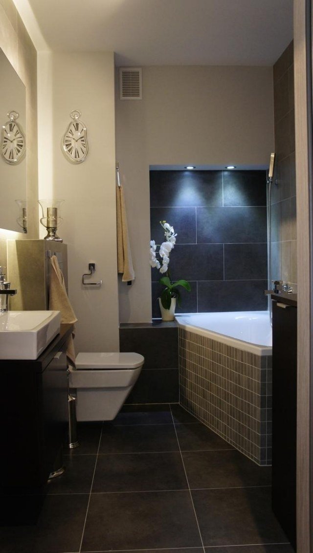litet badrum-möblering-hörn-bad-badkar-vägg-nisch-inbyggda-ljus-mörk-grå-golvplattor