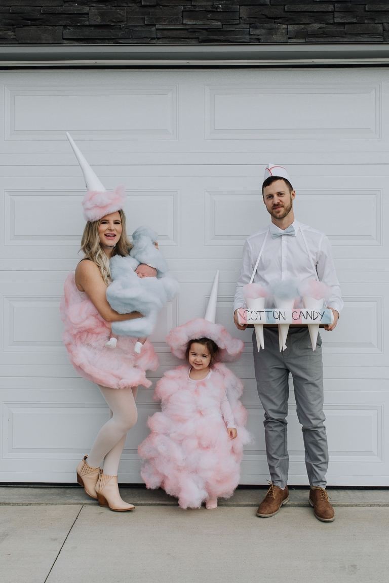 Familjedräktidéföräldrar med bebis och dotter till Mardi Gras sockervaddssäljare