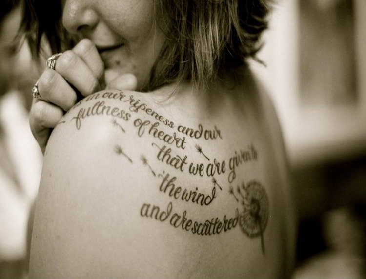 Tatueringsskrivningar-kvinna-säger-axelblad-maskros