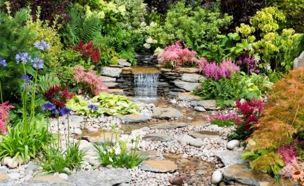 trädgård vattenfall stenar vackra färgglada blommor doft