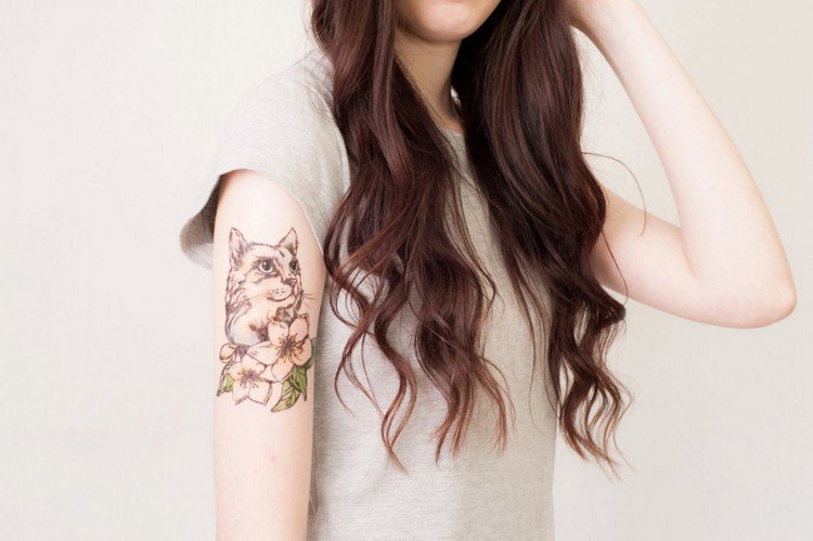 katt tatuering överarm bruna blommor