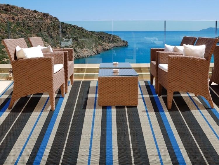 utomhusmattor-design-brun-ränder-svart-blå-terrass-utsikt-havsglasräcken-plastrotting