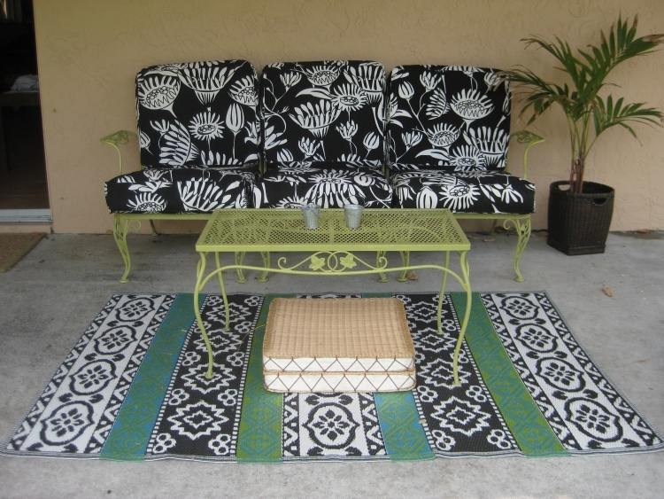 utomhusmattor-design-svart-vitt-mönster-gröna-trädgårdsmöbler-stoppade kuddar-sittdynor-palm-betonggolv