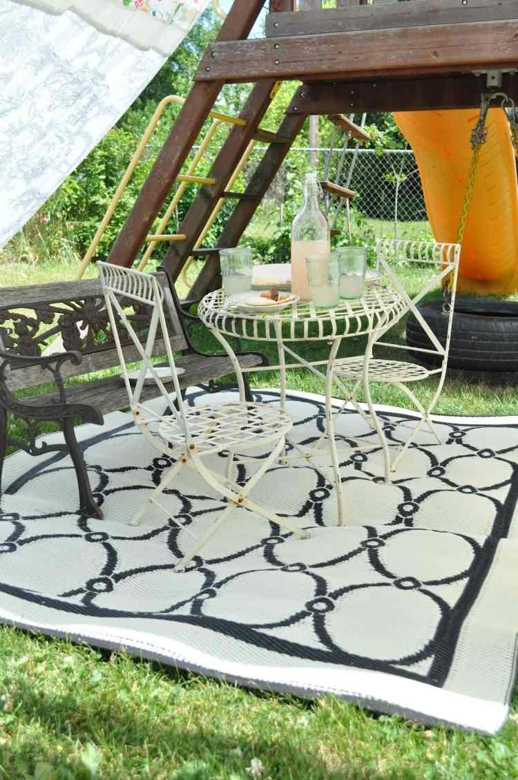 utomhus-mattor-design-svart-vitt-mönster-gräsmatta-skugga-stolar-järn-gunga-barnens område-picknick