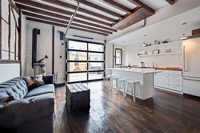 design-loft-lägenhet-kök-med-ö-vita-vägg-hyllor-öppna-rustika träbjälkar