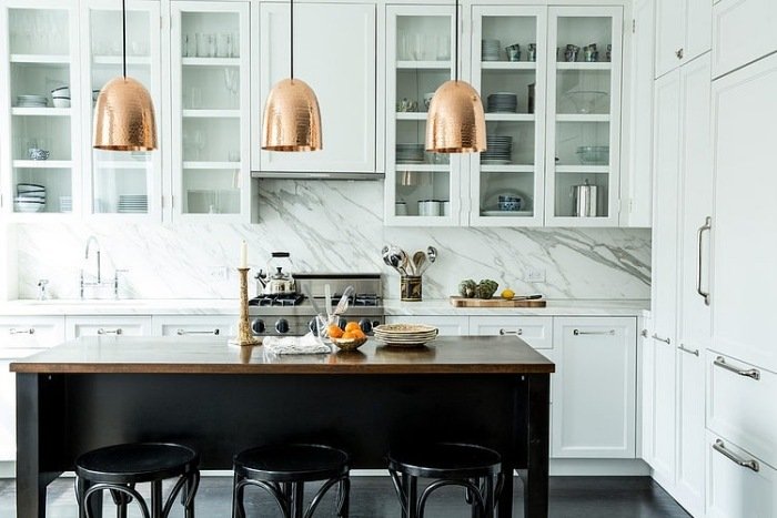 bakvägg i kök-vit-marmor-hängande-lampor-krom-köksskåp-metallhandtag